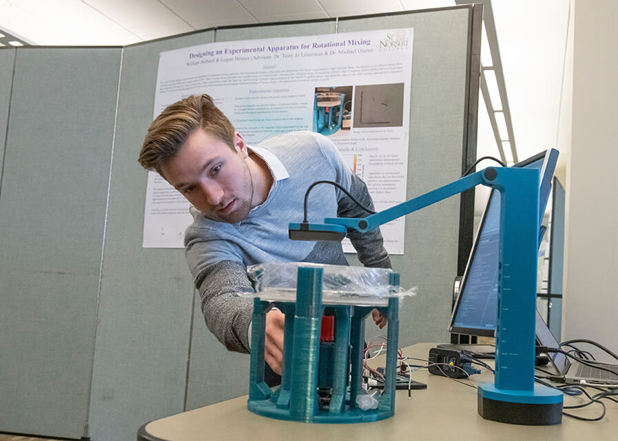 Physics student demonstrating part of a research project.