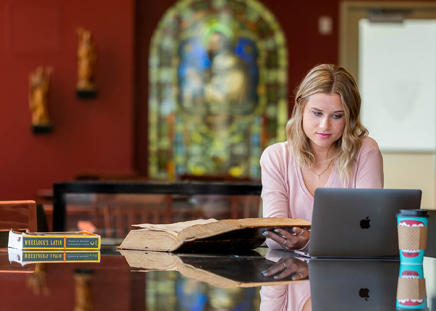 A Latin student works to translate Latin text.