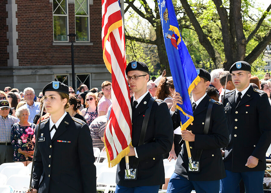 Military science students march with a color guard.