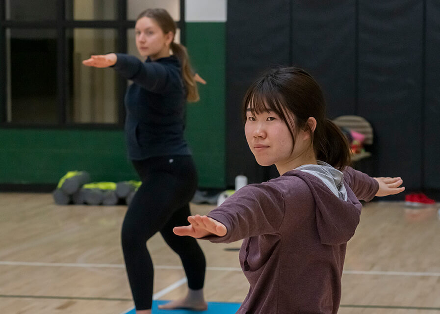 A student practices yoga in the Campus Center gym.