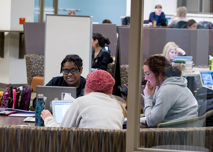 Students studying together at a table in the library.