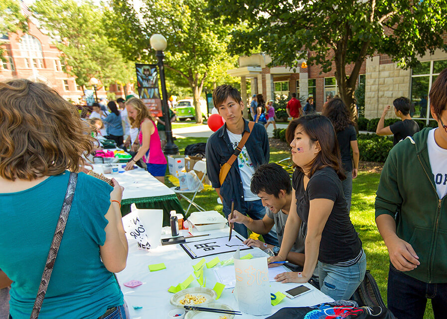 Modern languages and literature students at a table, speaking to guests during SNC Day