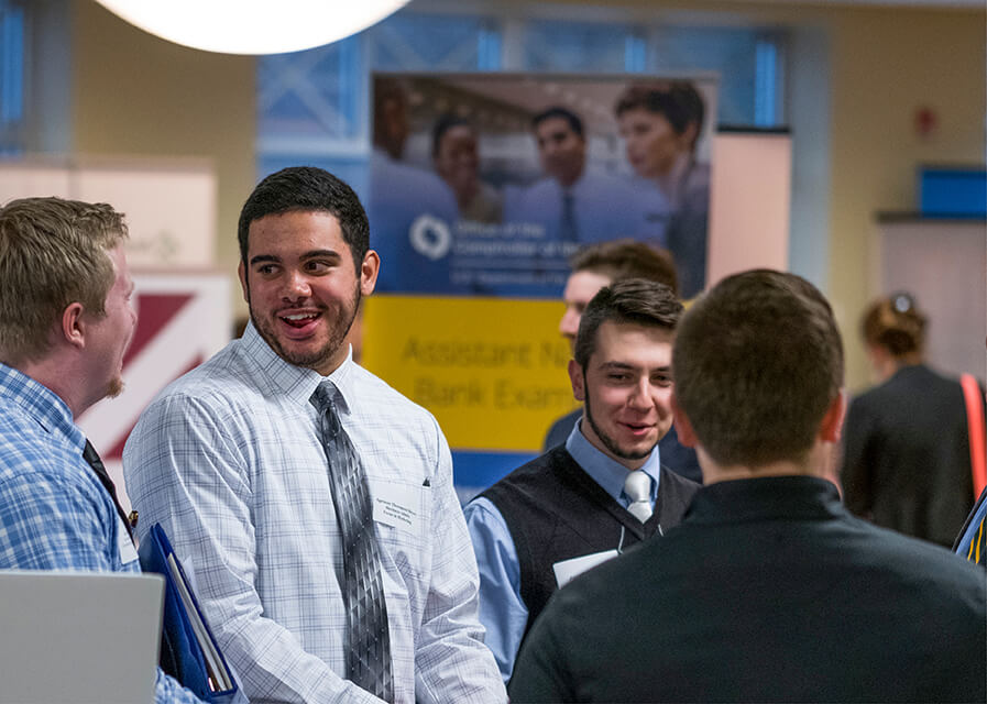 Students talk to prospective employers at a career fair on campus