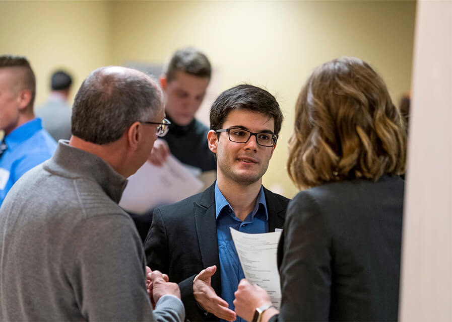 Student talks to prospective employers at a career fair on campus