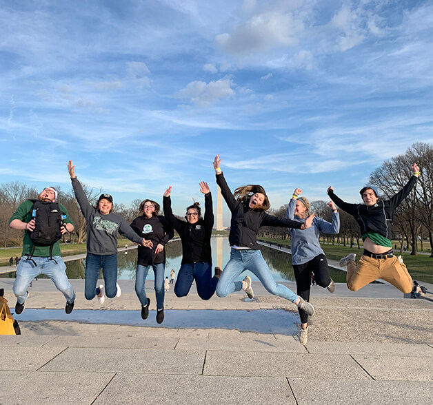 Students jump in front of the Washington Monument in Washington, D.C.