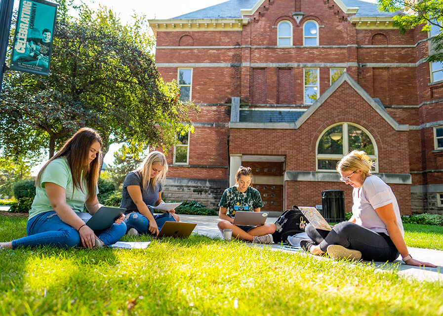 Students study on the lawn by Main Hall