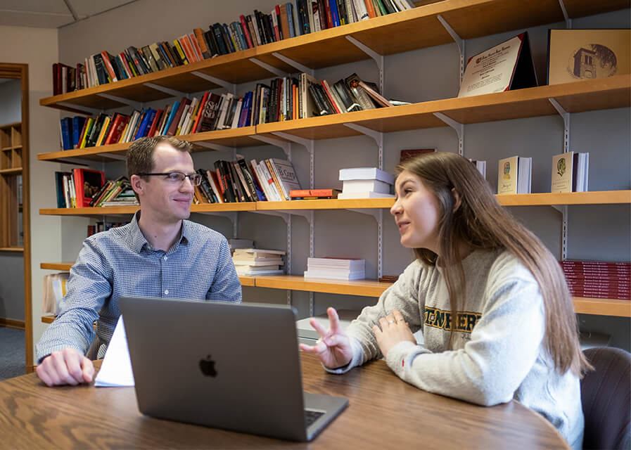 A faculty member helps a student