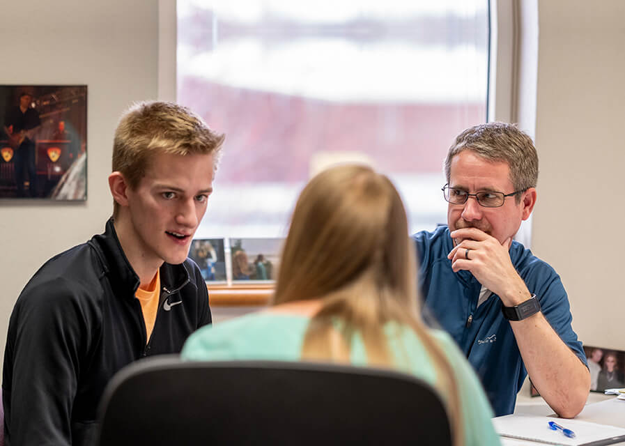 Students meet with professor during office hours.