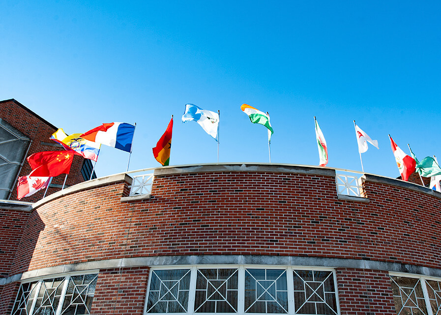 International flags stand on top of a building on campus.