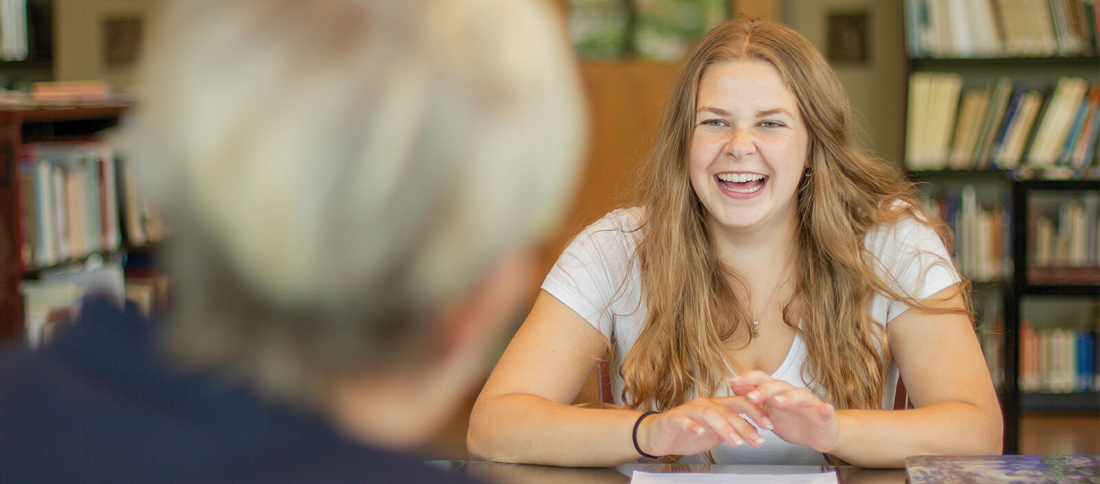 Student laughs during a discussion with her professor.