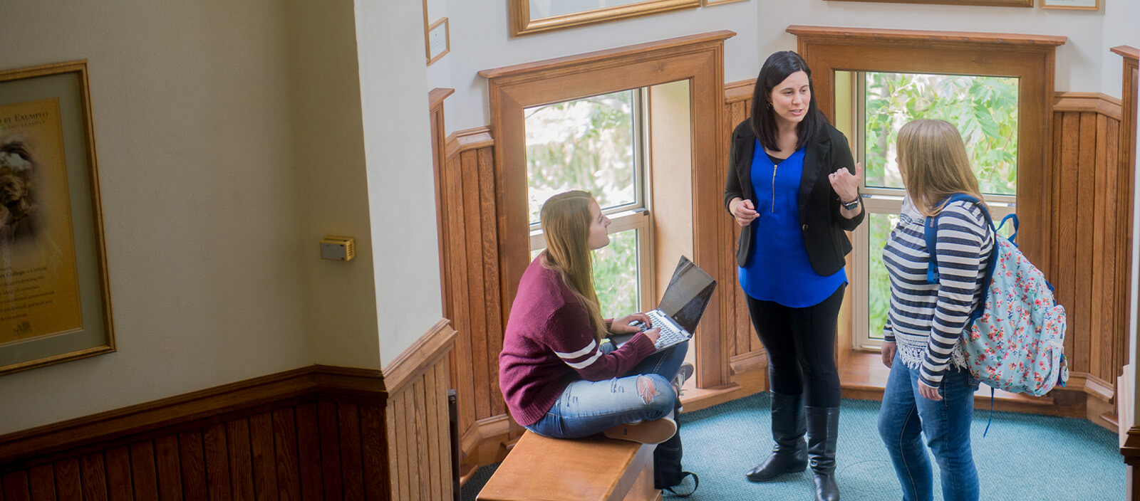 A St. Norbert College professor talks with two students.