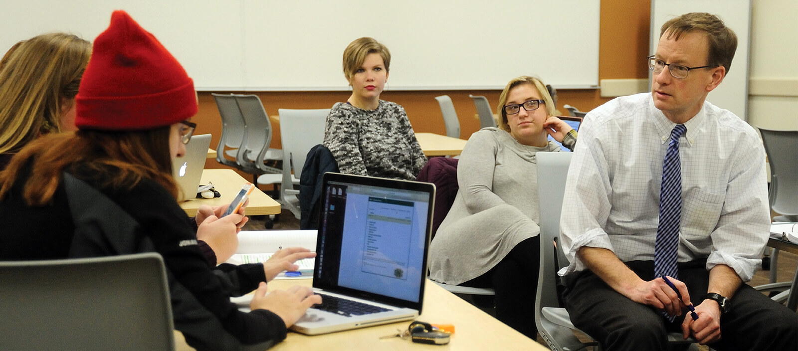 Professor facilitates a discussion group with students in class.