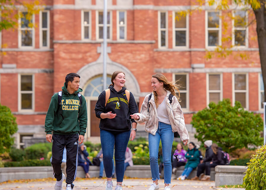 Students walking on campus in front of Main Hall