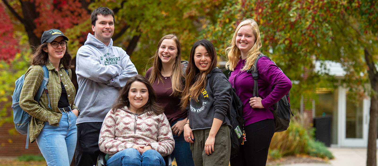 A group of students pose together for a photo on campus