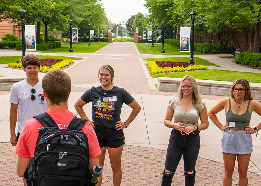 Students listening to a tour guide on campus