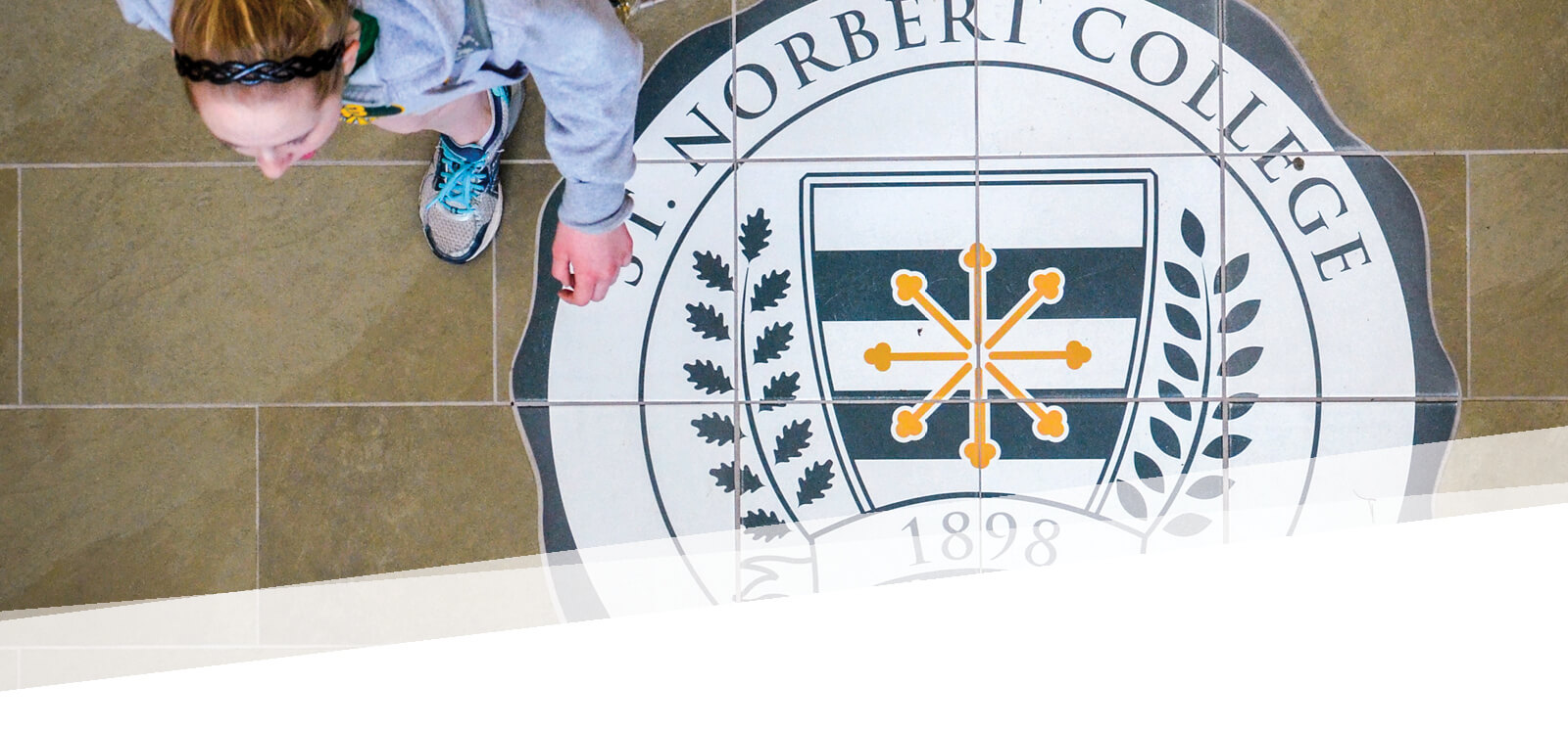 Overhead shot of the president's seal on the floor as a student walks over it
