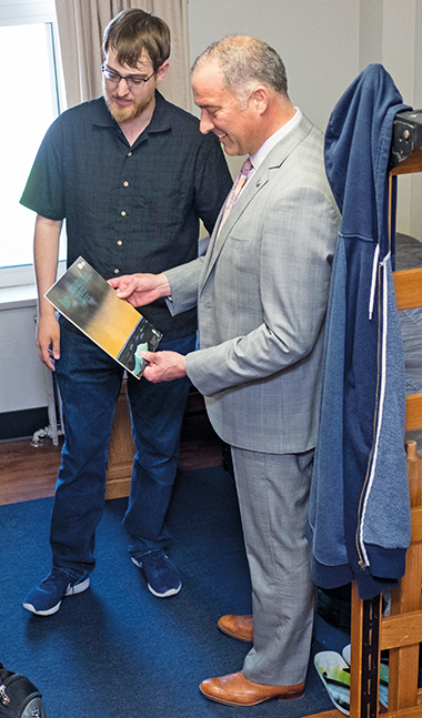 Nicolas Schmudlach and President Brain Bruess look at a record cover in Burke 215