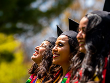 students smiling in their caps and gowns at graduation